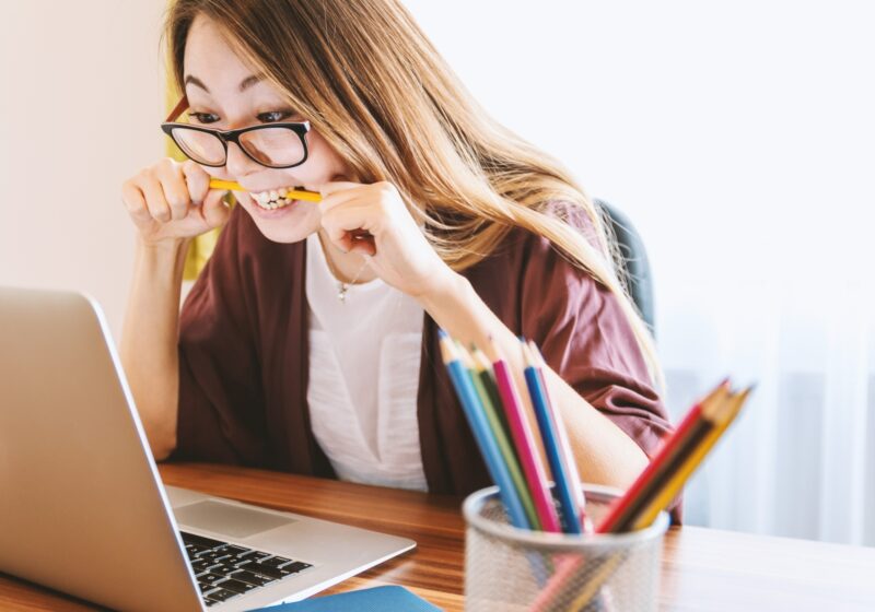Girl At Computer Biting Pencil